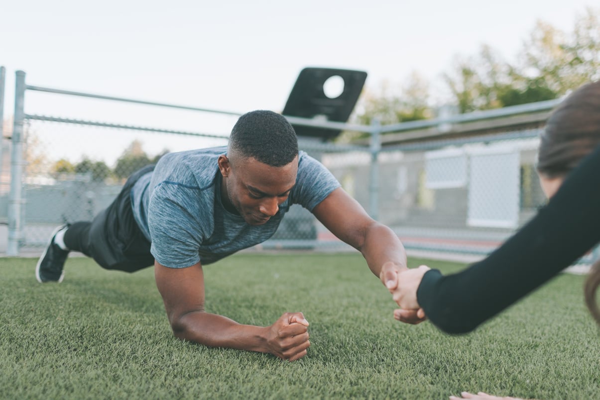 Man and Woman Planking While Holding Hands